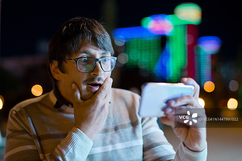 快乐的男人看着智能手机图片素材