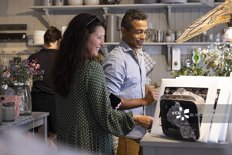 微笑的中年夫妇在商店里一起购物图片素材