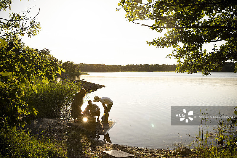 一家人在湖边享受夏日假期的日落图片素材