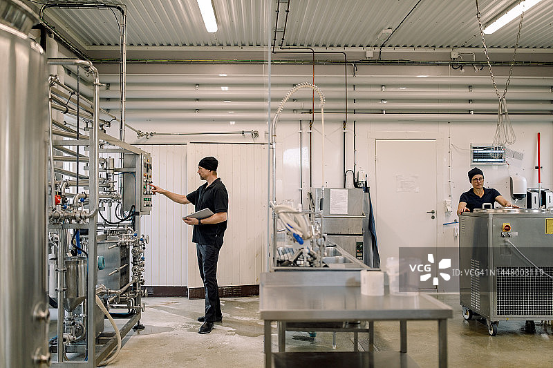 年长的农民在乳品厂操作机器图片素材