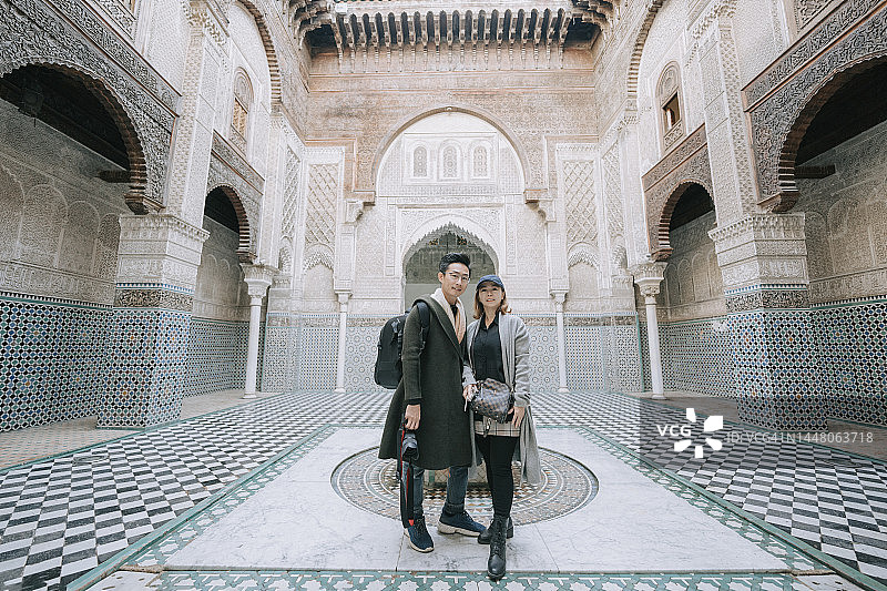 站在布伊纳尼亚神学院的亚洲华人游客情侣图片素材