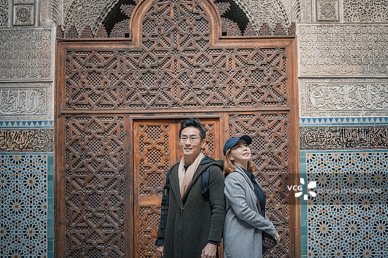 中国游客情侣在布伊纳尼耶神学院的费兹清真寺前合影图片素材