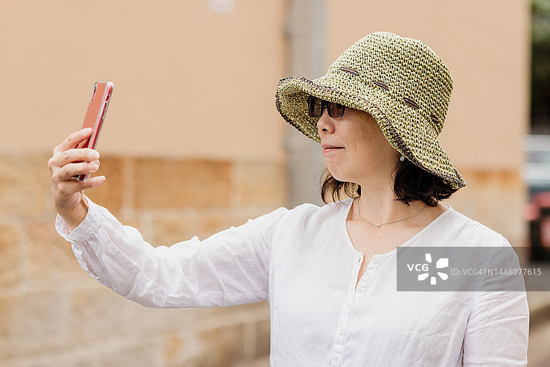 面带微笑的女人用手机自拍图片素材