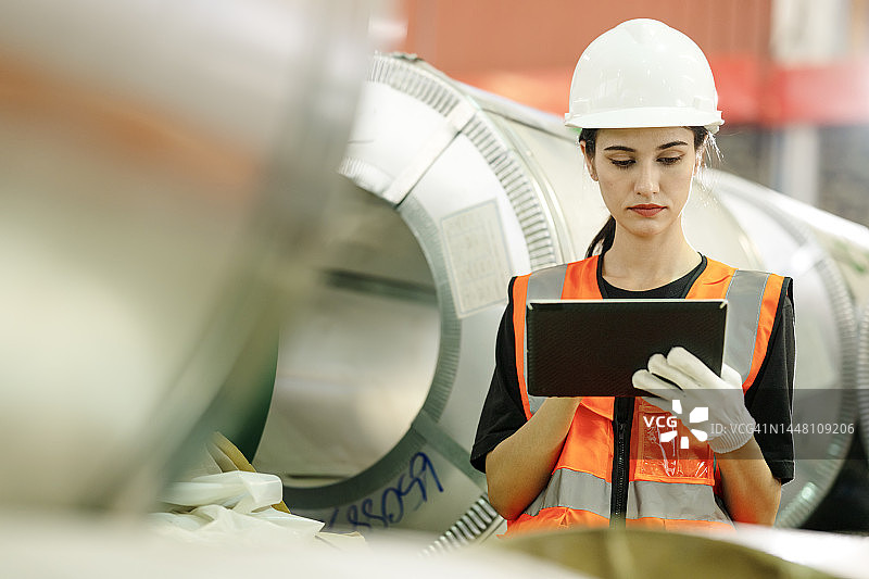 钢厂钢卷仓库，女性工人平板电脑管理存储图片素材