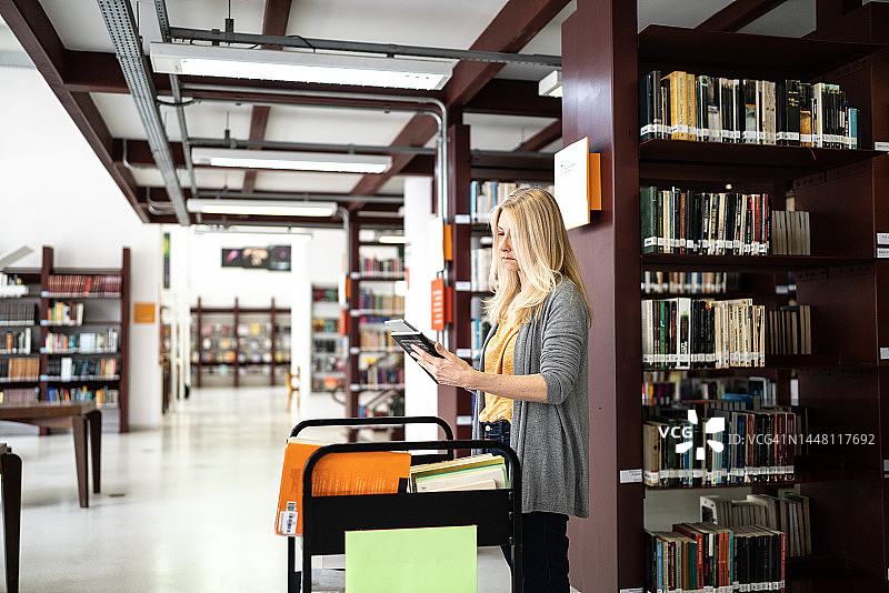 图书馆员将书放回书架图片素材