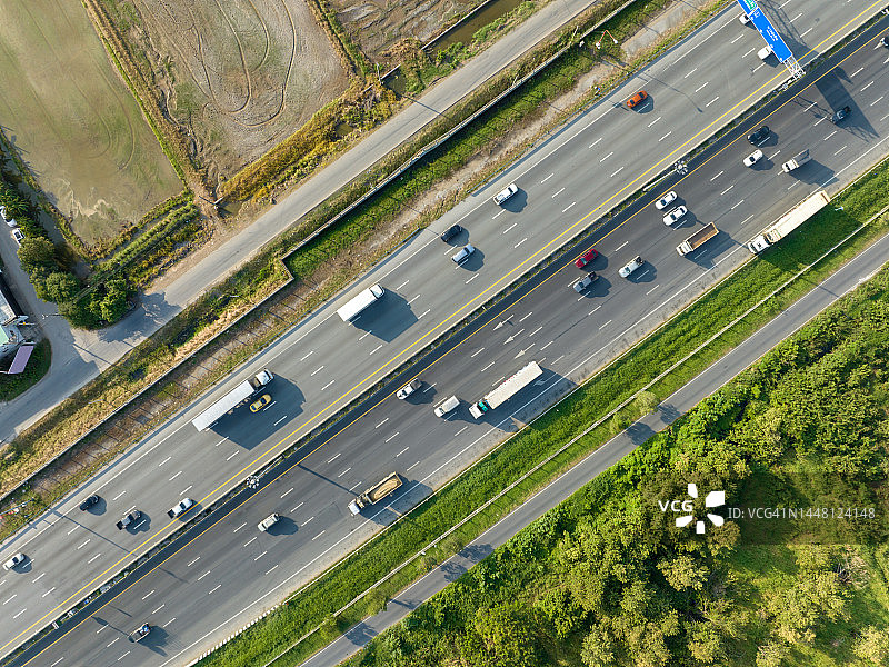 泰国曼谷繁忙的高速公路，汽车和卡车行驶在美丽的蓝天下航拍图图片素材