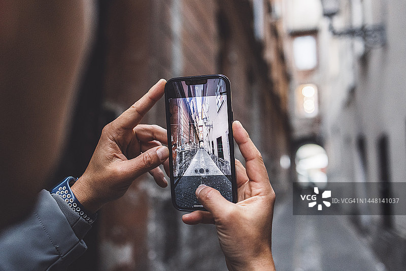 一名男子在城市里拿着手机散步图片素材