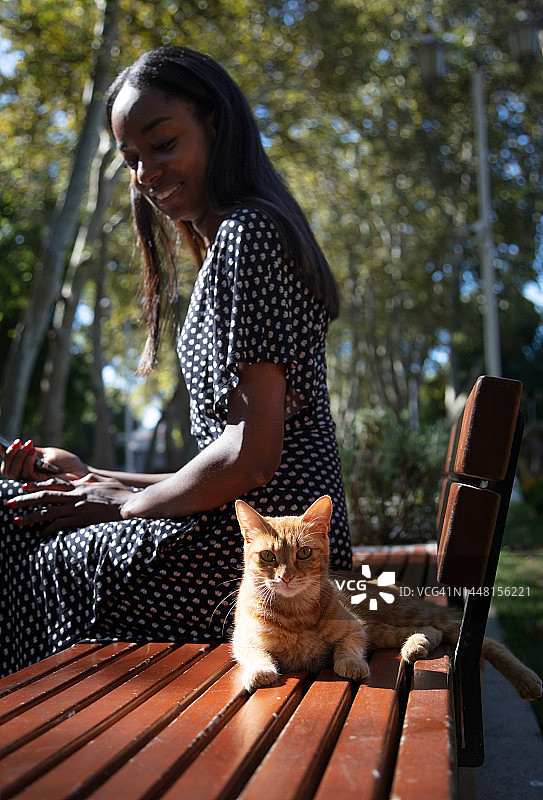 年轻的黑人女性在公园里发短信图片素材