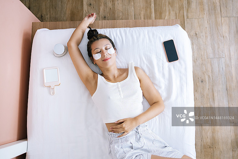 闭眼使用眼膜的快乐美丽女人图片素材