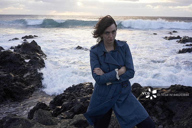 在刮风的海滩上自豪地看着镜头的女人图片素材