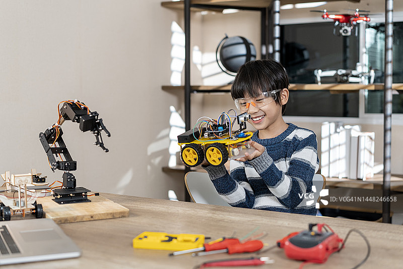 亚洲儿童在家组装开源软硬件机器人汽车图片素材