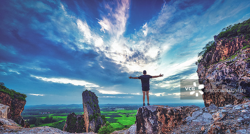 山顶上的剪影男人：成功、胜利、领导者概念图片素材