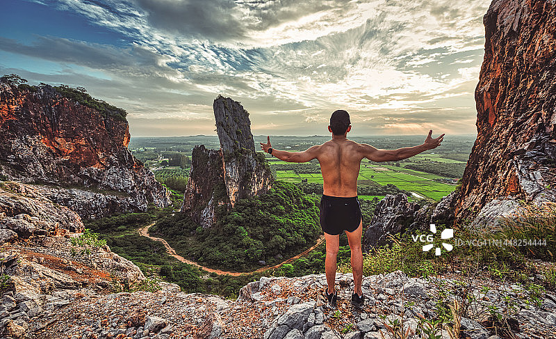男人站在山顶，象征成功和领导图片素材