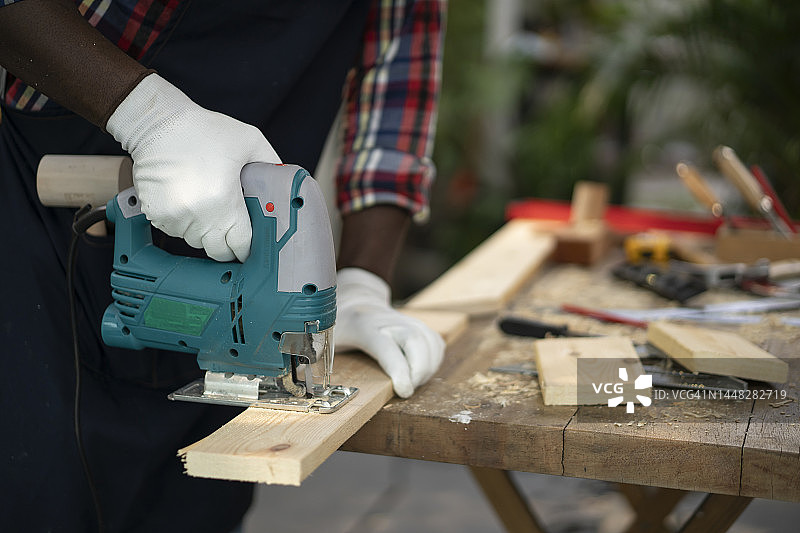 中年男人在车间里砍木头图片素材
