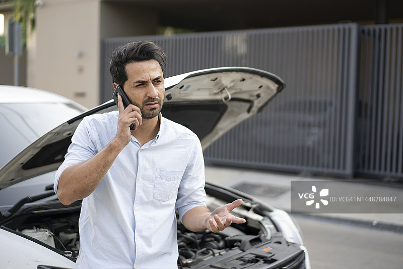 汽车抛锚后呼叫救援的男子图片素材