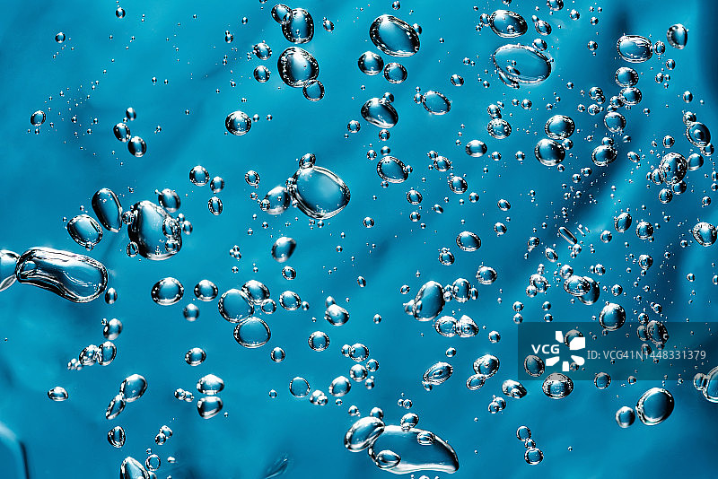 蓝色气泡背景的芦荟凝胶精华化妆品特写图片素材