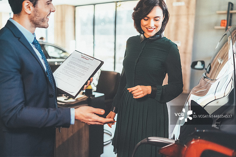 女商人购买新电动汽车图片素材