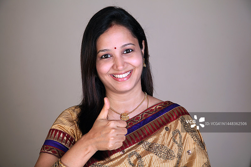 快乐的年轻传统服饰女性竖起大拇指图片素材