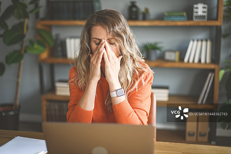 在家工作的年长女性（笔记本电脑，文件，负面情绪）图片素材