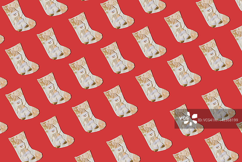 红色背景上的圣诞袜图案，饰有雪人和金色装饰图片素材