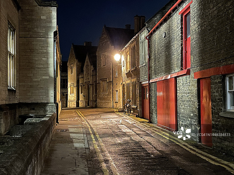 英国Oundle的夜间小巷，自行车被路灯照亮图片素材