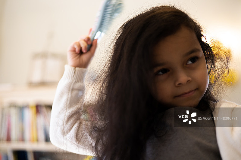 正在梳头的年轻混血女孩图片素材