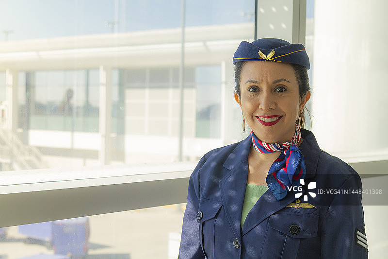 笑容满面、自信的拉丁裔空姐 портрет，欢迎乘客图片素材