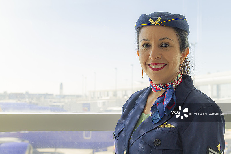 笑容满面、自信的拉丁裔空姐 портрет，欢迎乘客图片素材