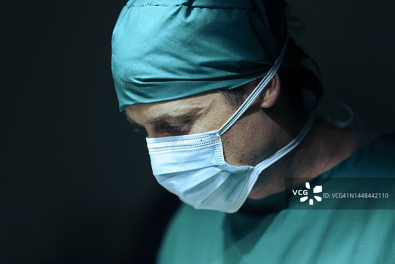 年轻外科医生戴着外科口罩进行手术的特写图片素材