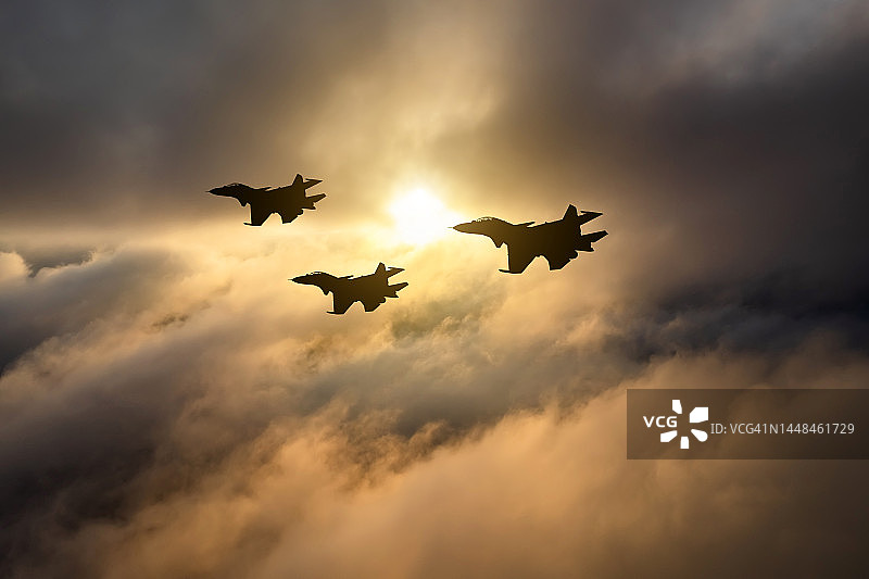 日落时云层中的战斗机：军事航空图片素材