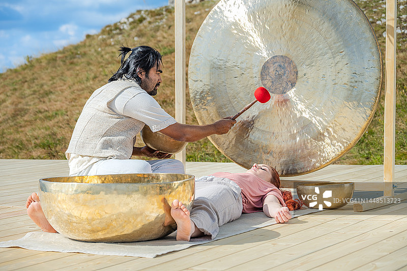 男子敲锣进行声音疗法图片素材
