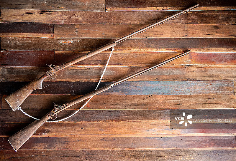 挂在木板墙上的古董枪械图片素材