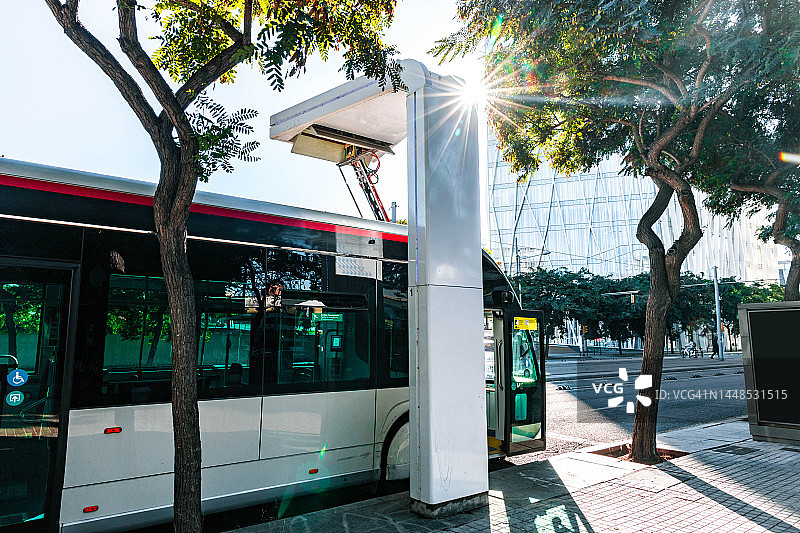 在公交车充电站快速充电的电动生态公交车。可持续交通。图片素材