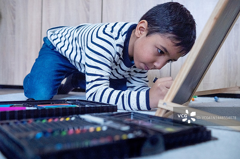 小孩在家里的白板上画画图片素材