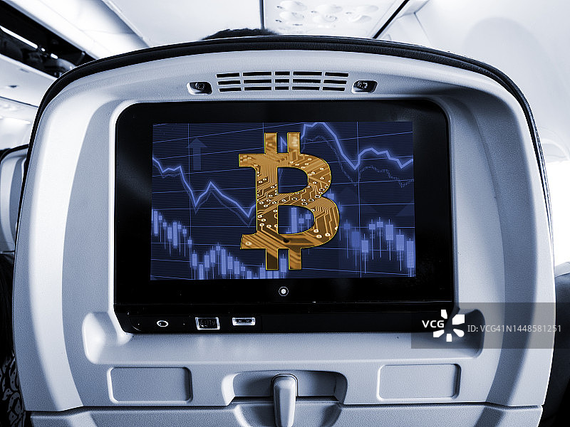 飞机座位娱乐屏显示比特币符号和金融市场数据图片素材