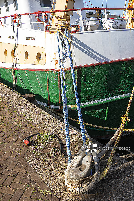 系缆绳的渔船停靠在系泊柱旁图片素材