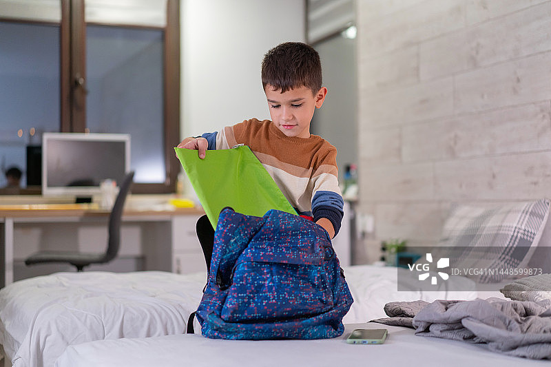 学生在房间里整理书包准备上学图片素材