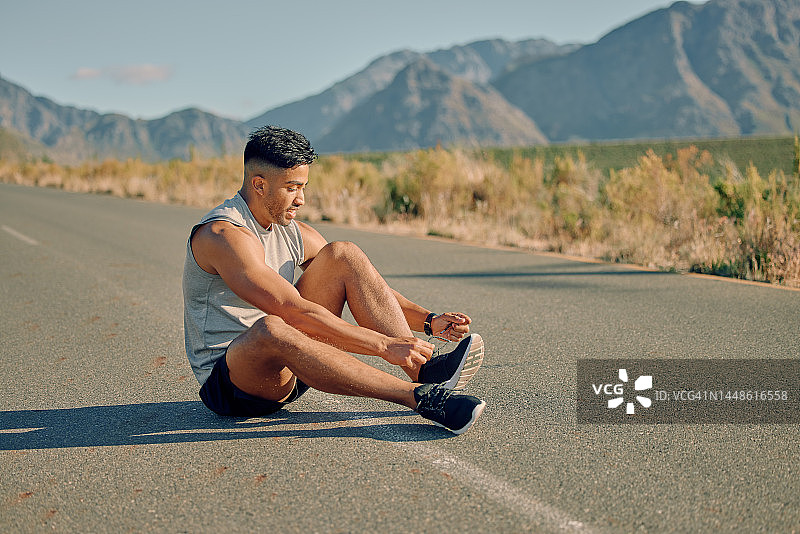 跑步者在道路上系鞋带准备跑步，进行有氧运动或为夏季马拉松训练。健身、健康或运动型运动员准备鞋带开始户外锻炼图片素材