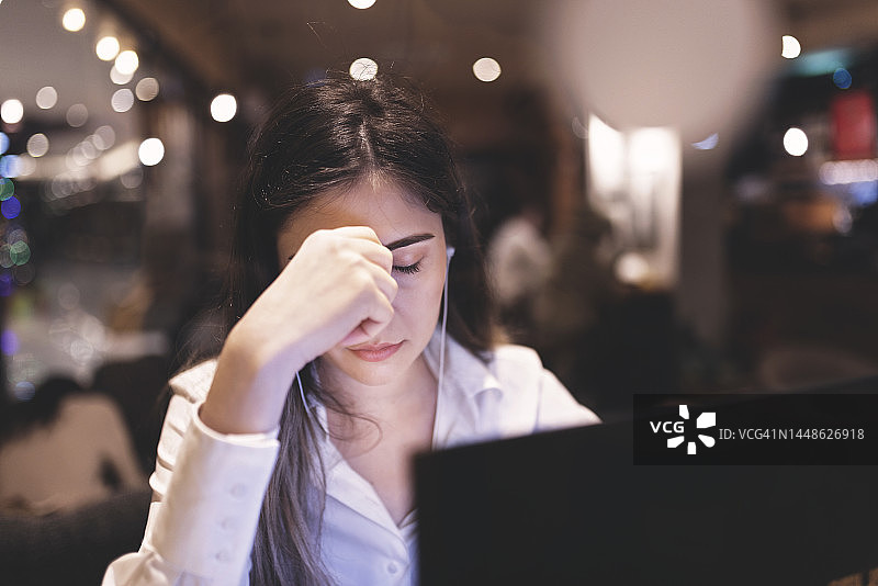 在电脑前疲惫的年轻女商人图片素材