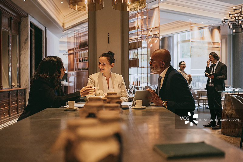 在餐厅午餐会上讨论问题的多种族男女同事图片素材