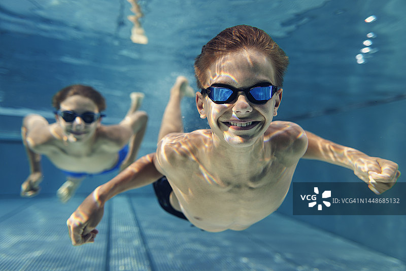 在游泳池里水下游泳的青少年图片素材