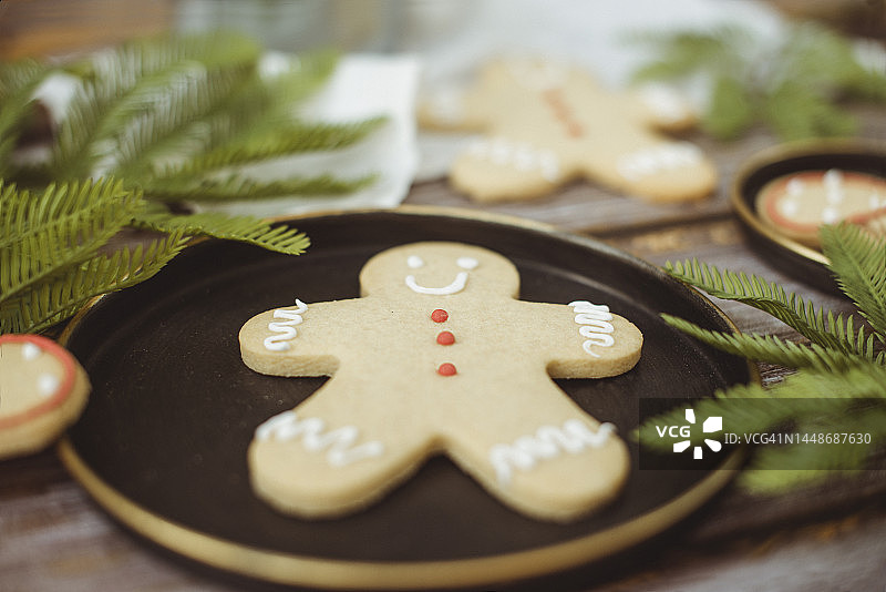 木桌上姜饼人饼干的特写，配有冷杉树枝和蕾丝桌布图片素材