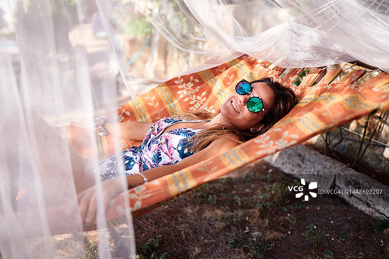 微笑的西方女人躺在吊床上图片素材