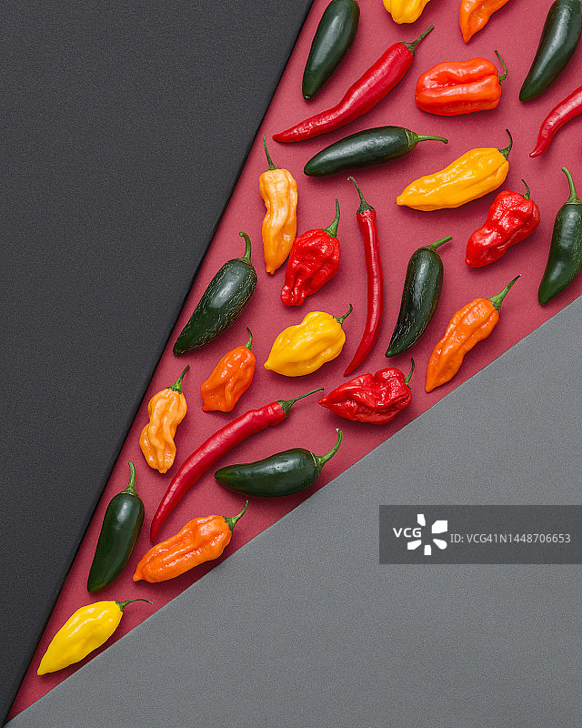 彩色纸上的什锦辣椒：红色辣椒、黄色和橙色哈瓦那辣椒、绿色墨西哥辣椒图片素材