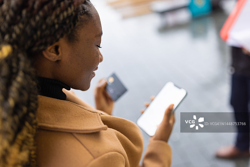 黑人女性使用手机App进行在线购物图片素材