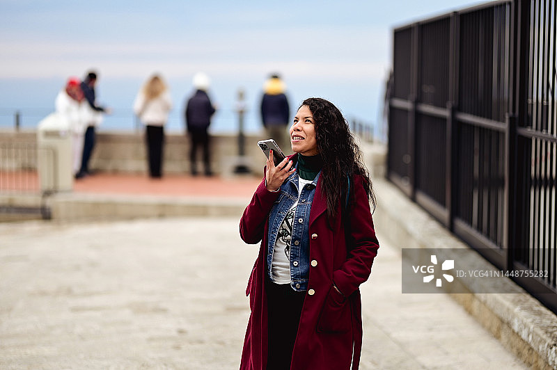 巴西女人在打电话，享受冬季周末。图片素材