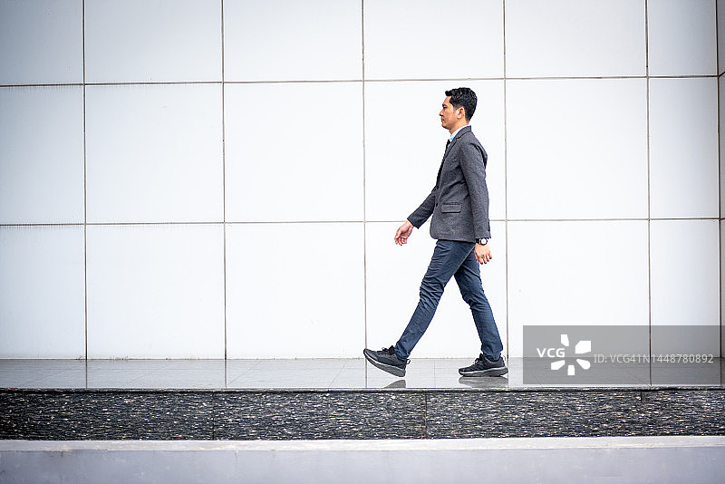 年轻商人走过办公楼图片素材