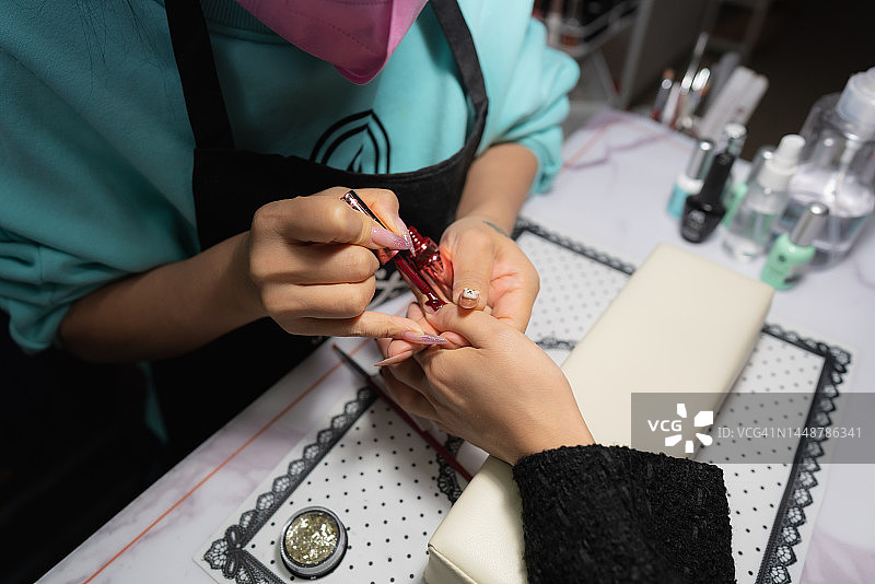 美甲师为顾客做美甲特写图片素材