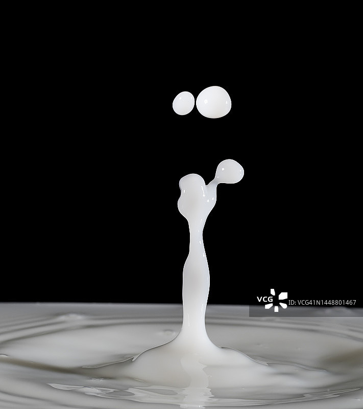 滴落在黑色背景上的牛奶图片素材