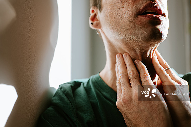 男子按摩酸痛的颈部/喉咙图片素材